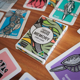 Colorful card game box surrounded by cards on a wooden surface