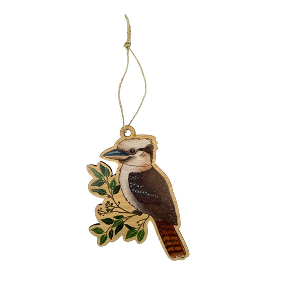Decorative ornament of a kookaburra on a branch with leaves, hanging from a string against a white background.