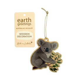 Wooden koala decoration with a tag labeled 'earth greetings' on a white background