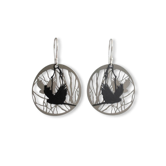 Pair of earrings with black cockatoo bird silhouette design on a white background