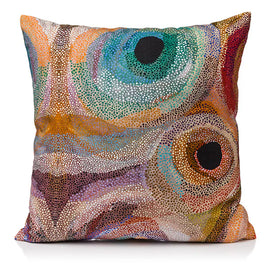 Colorful aboriginal art patterned pillow on a white background