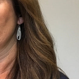 Close-up of a person wearing a silver earring with a white background