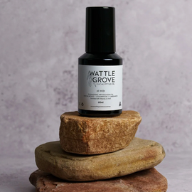 Bottle of Wattle Grove on stacked stones with a gray background