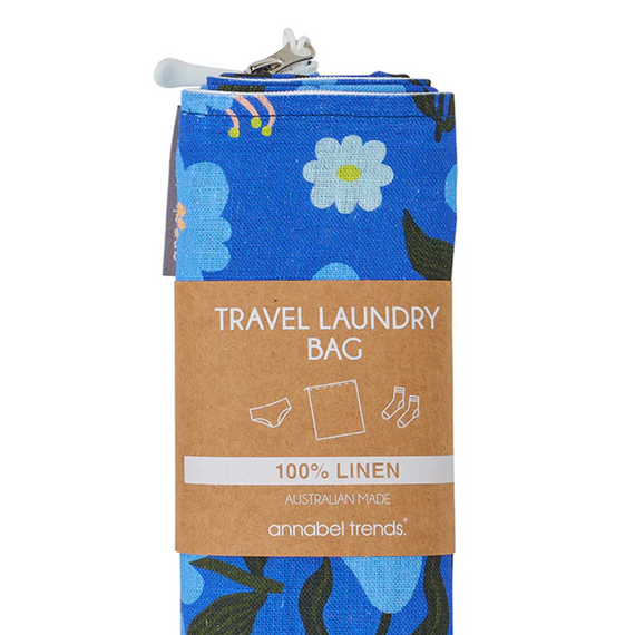 Blue floral travel laundry bag with a brown label on a white background