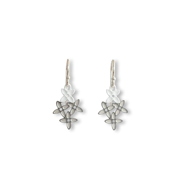 Pair of silver earrings with intricate designs on a white background