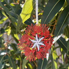 Decorative red and white Tasmanian Blue Gum flower ornament hanging from green leaves
