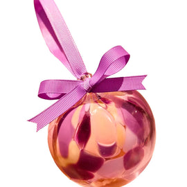 Pink and orange marbled ornament with a pink ribbon on a white background