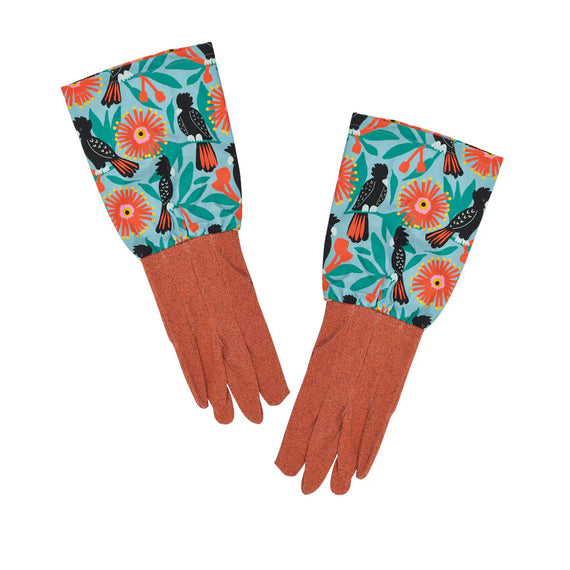 Pair of gloves with floral and bird pattern on cuffs against a white background