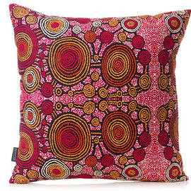 Decorative pillow with a vibrant, aboriginal art pattern on a white background