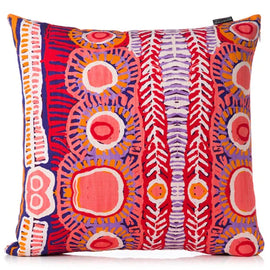 Colorful patterned pillow with aboriginal art design on a white background