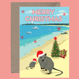 A Christmas card featuring a beach scene with two quokkas, a Christmas tree, and a boat in the background, with the text 'Merry Christmas' on the top.