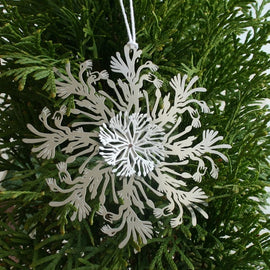 A Christmas ornament featuring a stylized kangaroo paw with a powder-coated finish in red, white, and gold colors, made from raw stainless steel.